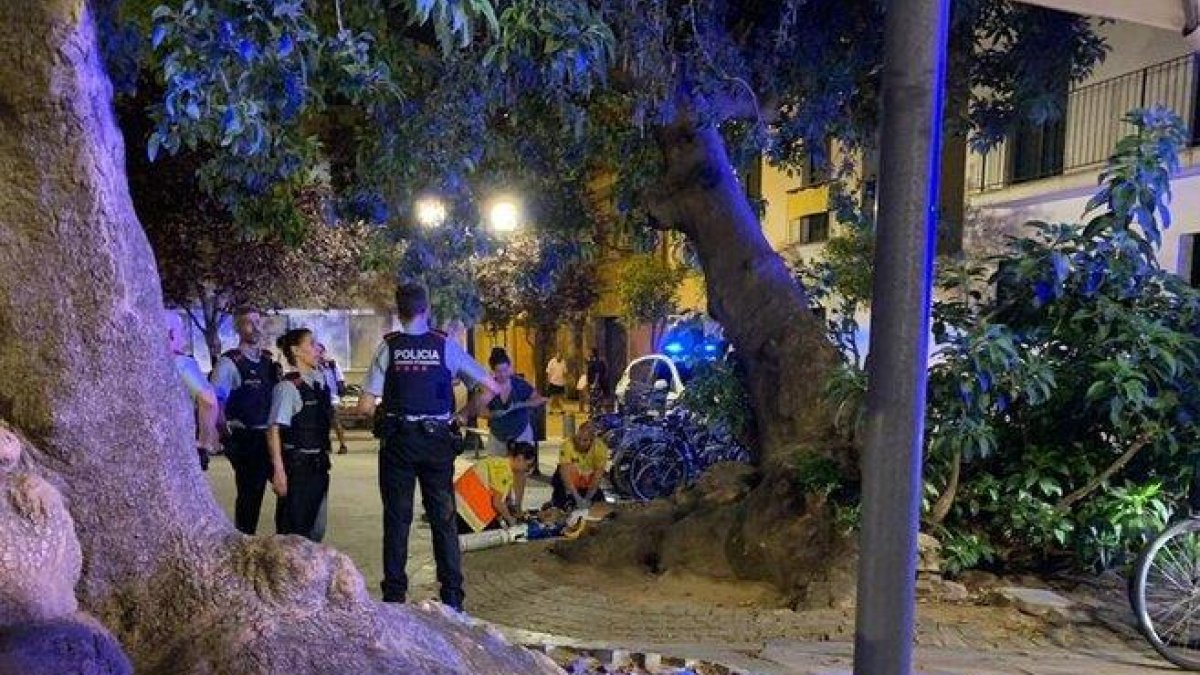 Mossos y personal sanitario atienden al joven herido anoche en Poblenou.