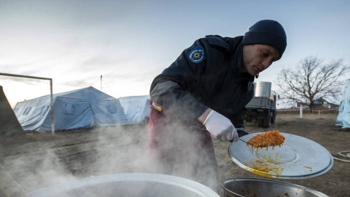 Un soldado prepara comida en un campo de refugiados de Palanca Village, a un kilómetro de la frontera entre Moldavia y Ucrania. DUMITRU DORU