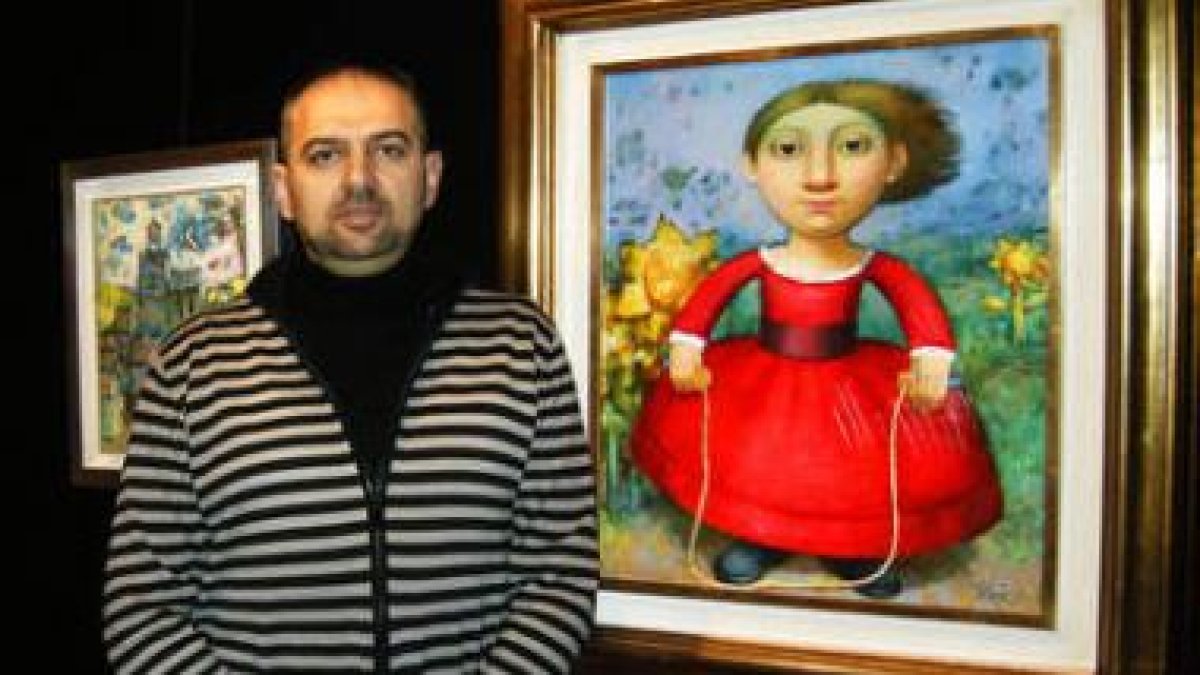 El pintor Álvaro Reja ante uno de los cuadros de la exposición.