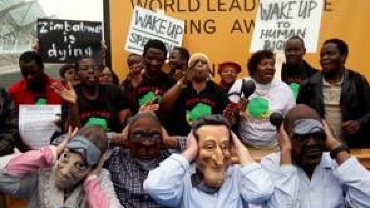 Manifestantes con máscaras de Merkel, Mugabe, Sarkozy Ahmed exigen respeto a los derechos en África