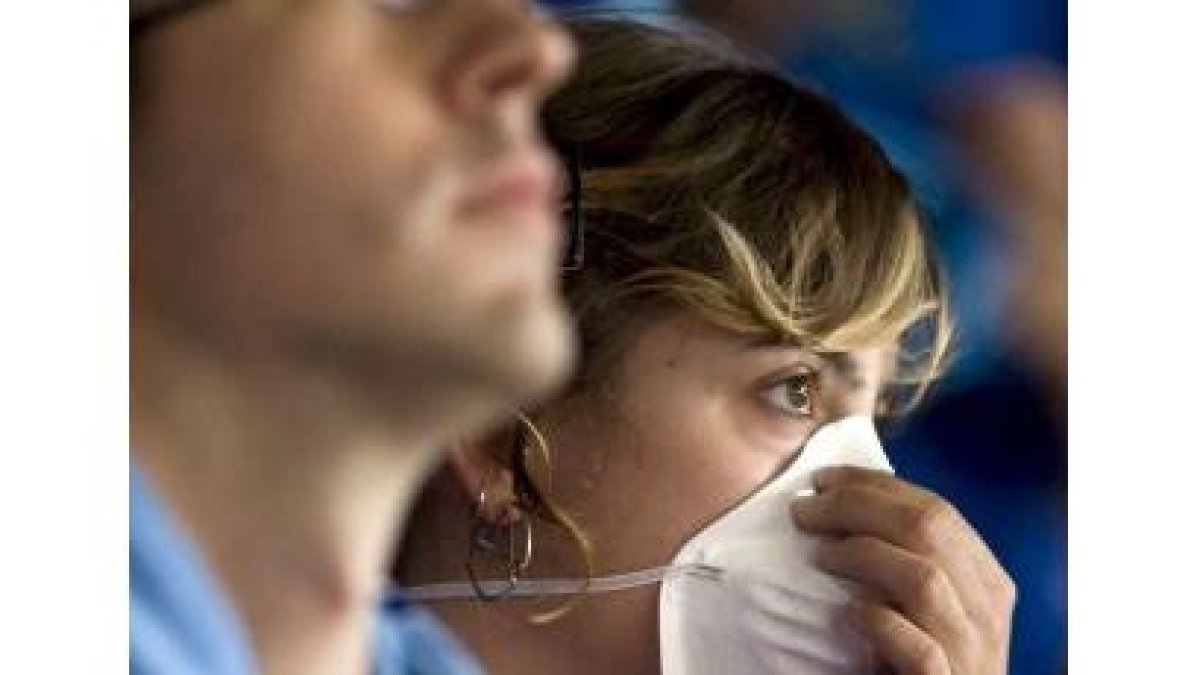 Una aficionada del Estudiantes lleva una mascarilla por el brote de gripe A que ha afectado a varios
