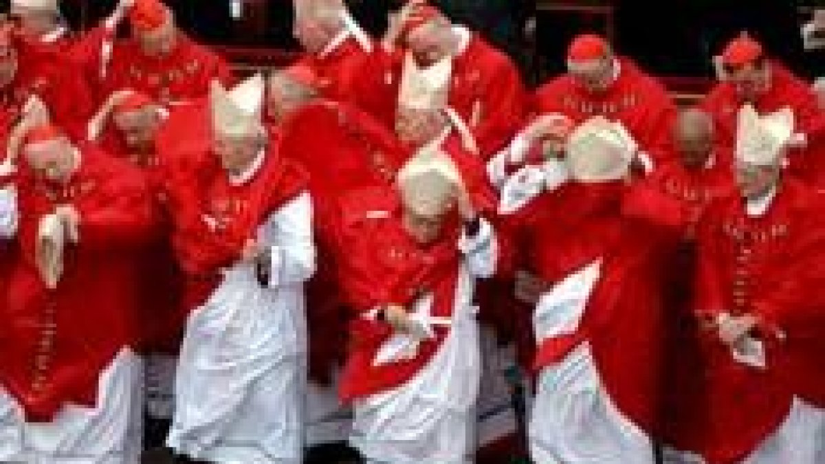 Un grupo de cardenales lucha contra el viento, en un momento del funeral