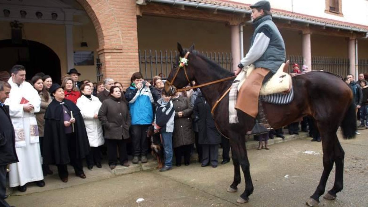 Un joven recita desde su caballo, ante el sacerdote, la mayordomo de la cofradía y el público, un poema en honor a San Antón.