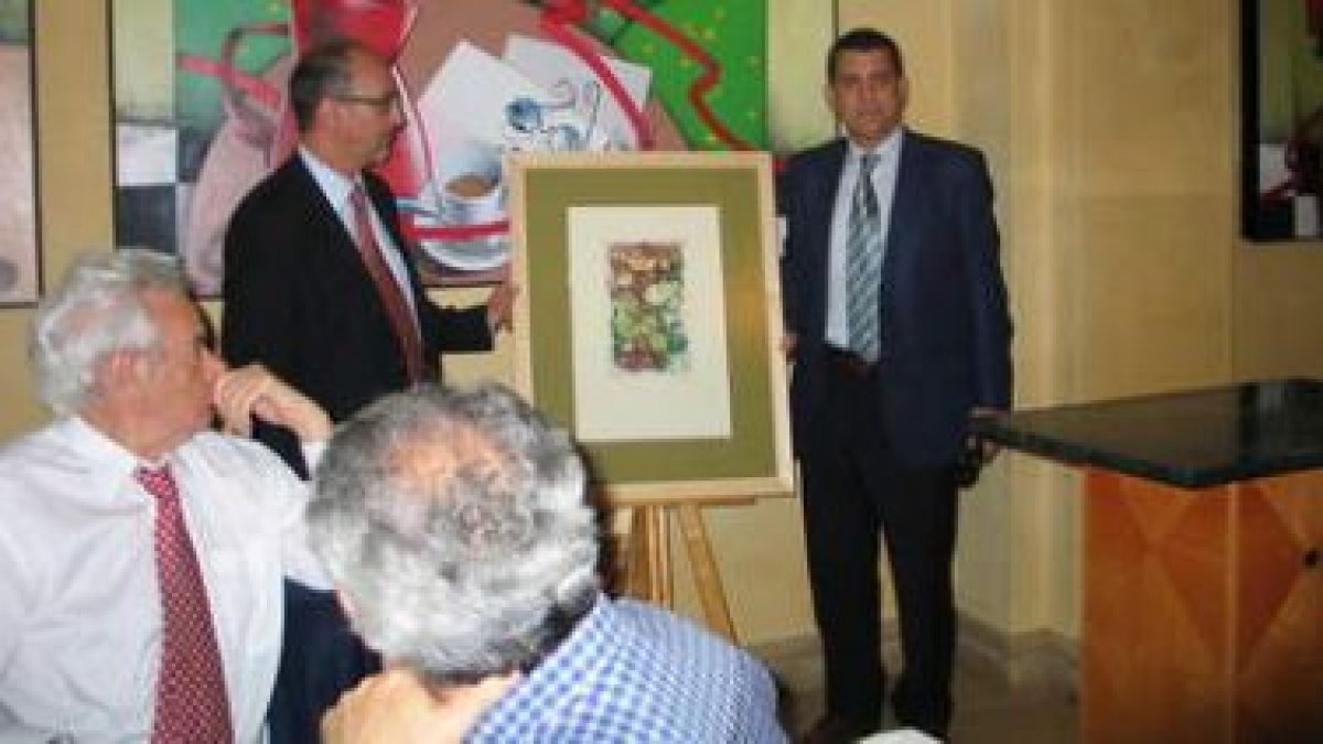 Luis del Olmo observa a Jorge Peña entregar el premio de la oenegé al alcalde de Ponferrada.