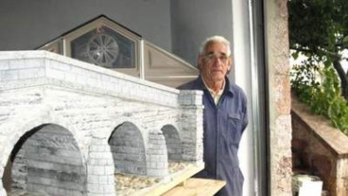 José Luis Sierra junto a la maqueta del puente viejo de Boca de Huérgano hecha en piedra y madera.