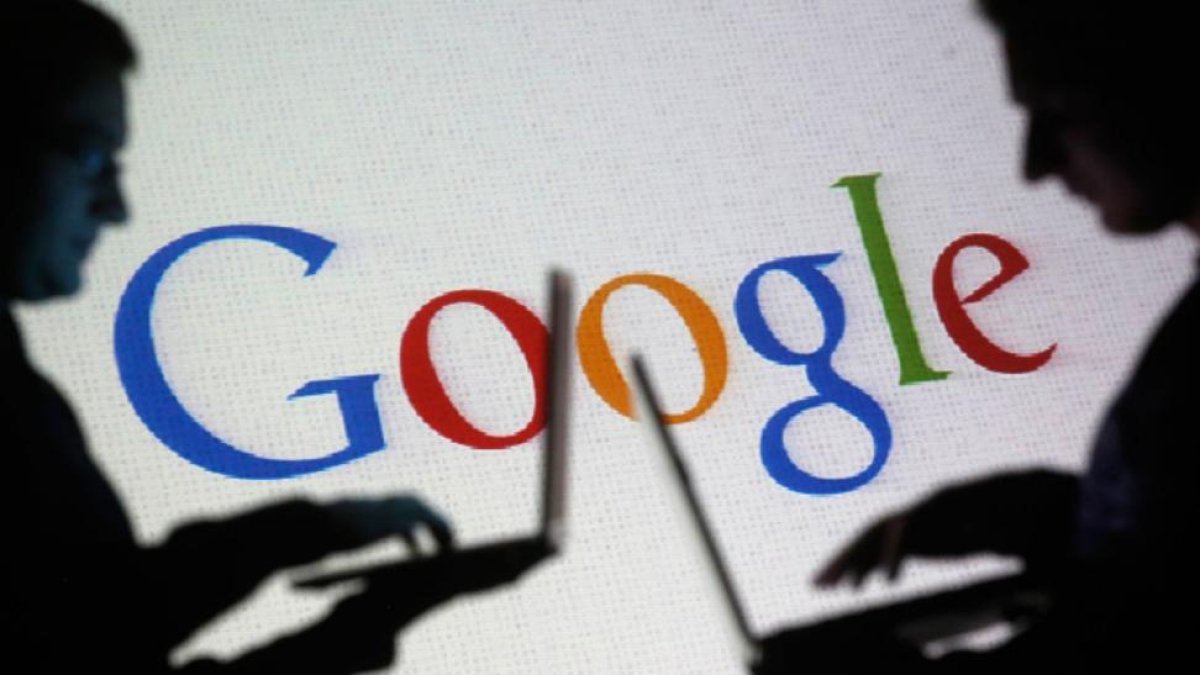 La silueta de dos hombres con el logo de Google de fondo.