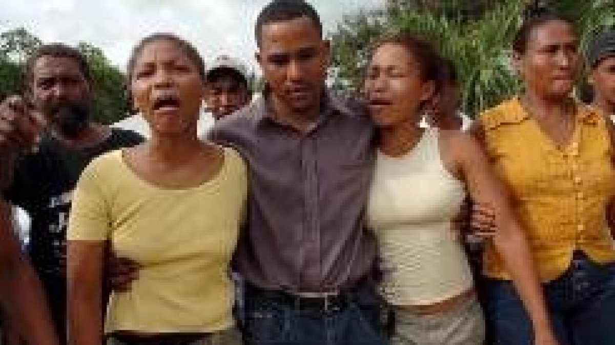Los hermanos de José Luis Burgos lloran durante el funeral