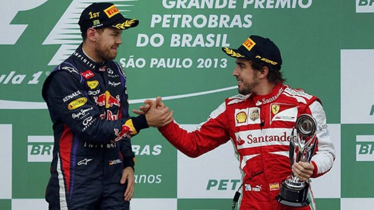 Fernando Alonso, tercero en Brasil, felicita a Sebastian Vettel por su victoria.