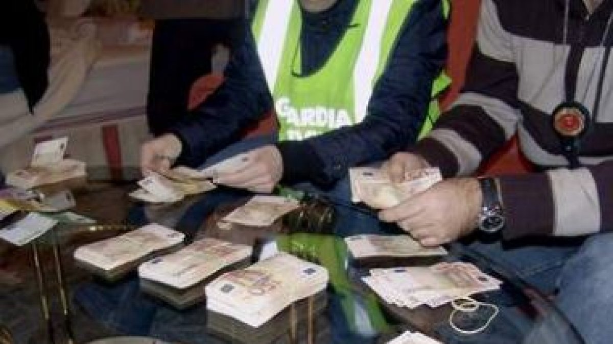 Agentes manipulan parte de los 500.000 euros encontrados durante la operación Toscana.