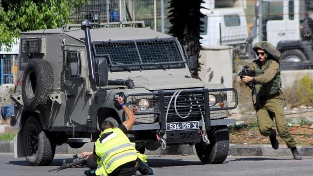 Un palestino, con un chaleco fluorescente y el distintivo de «prensa», acuchilla a un soldado israelí en Hebrón. Los soldados mataron después al agresor.