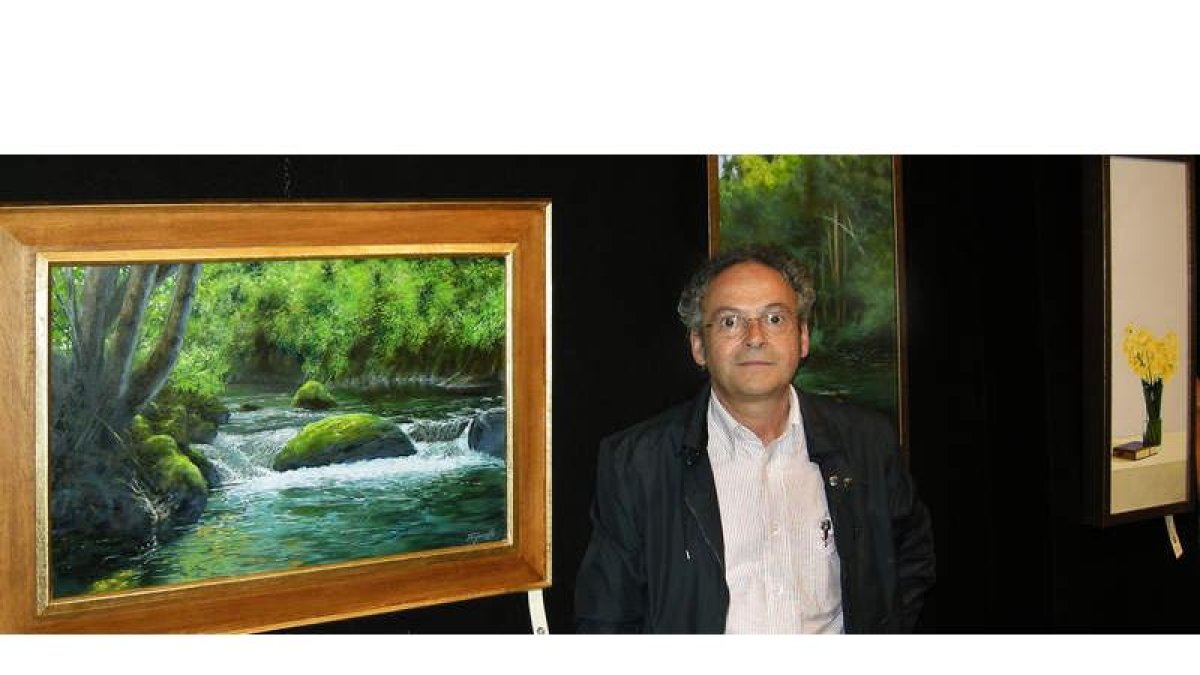 Seve Trapiello posa delante de algunas de las obras que expone en la galería leonesa Bernesga.