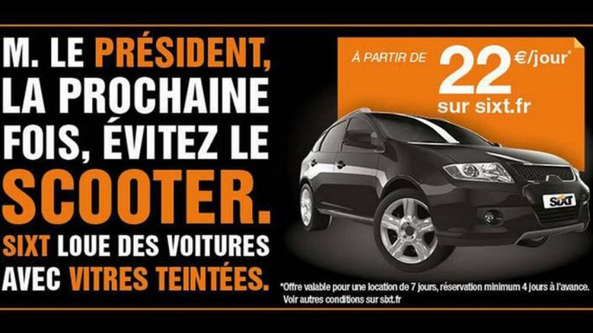Foto de una publicidad de una empresa de alquiler de vehículos en la que se insta a Hollande a cambiar la moto por un coche con los cristales tintados.