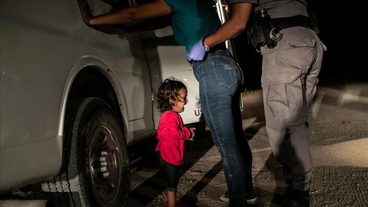 Yana, de Honduras, llora mientras su madre, Sanda Sánchez, es registrada por un agente fronterizo en McAllen, Texas, Estados Unidos.