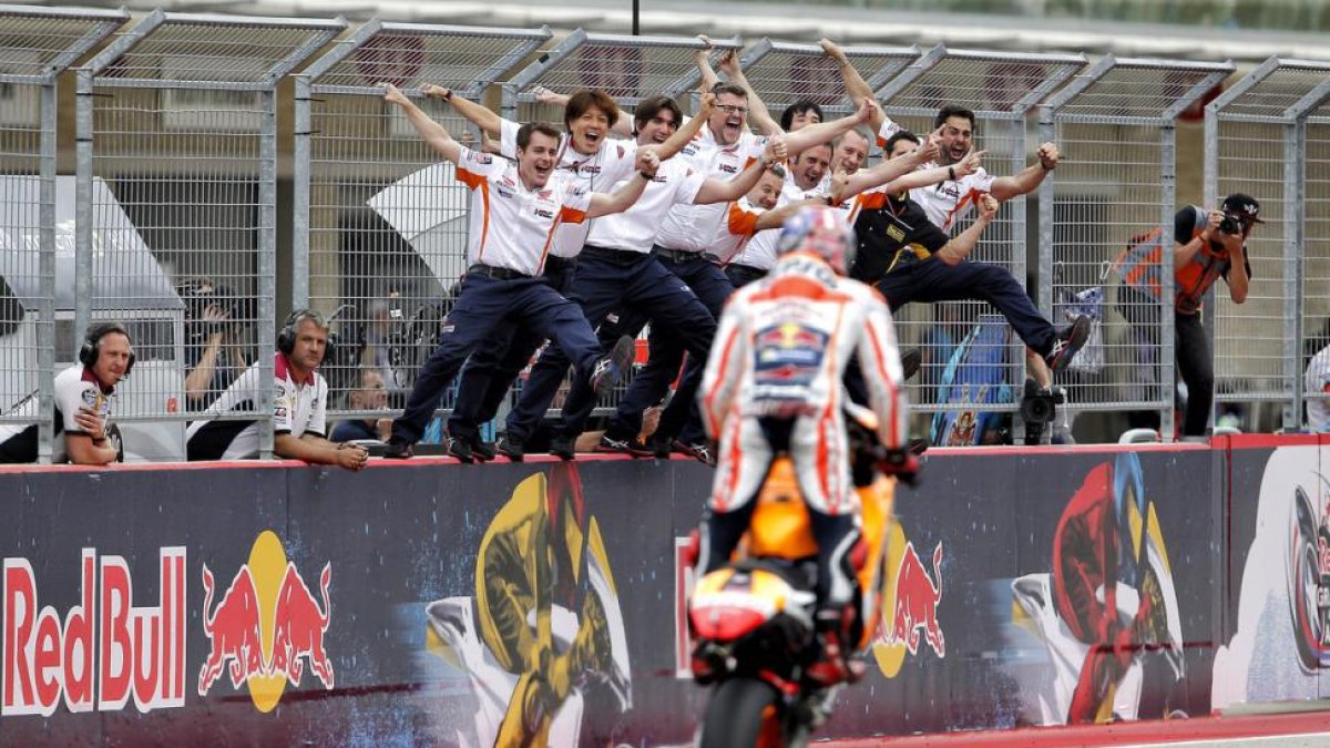 Los mecánicos de Marc Márquez reciben a su campeón encaramados al muro de Austin tras su última victoria.