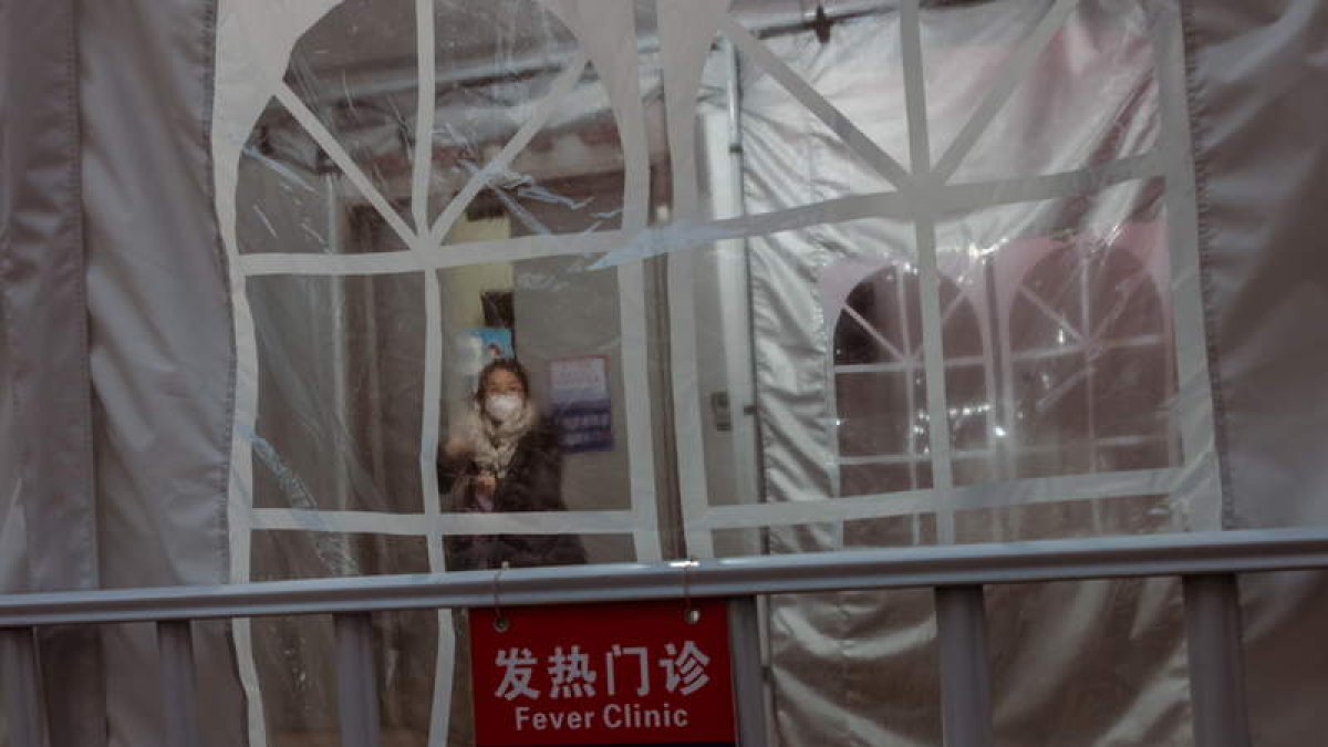 Una mujer sale de la clínica de fiebre en Shanghái. ALEX PLAVEVSKI