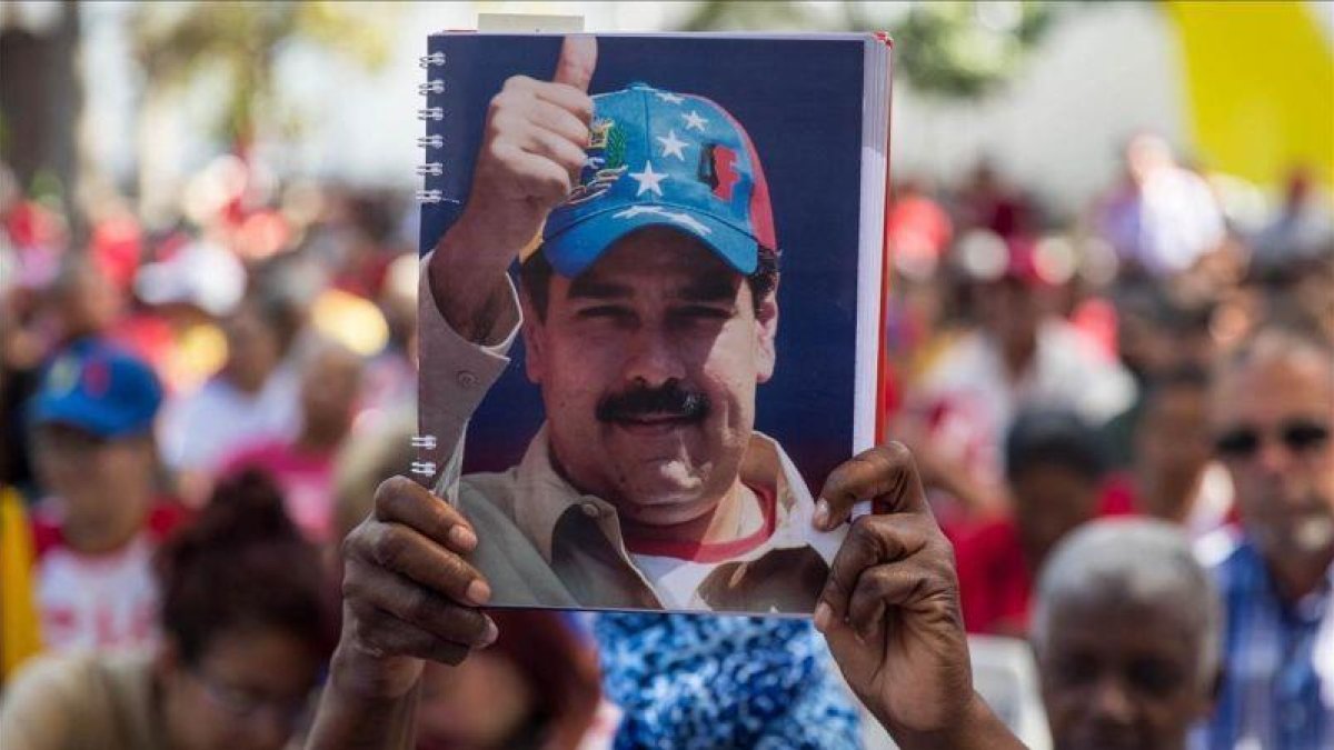 Una mujer seguidora del oficialismo venezolano sostiene una fotografía del presidente Nicolás Maduro el pasado sábado.