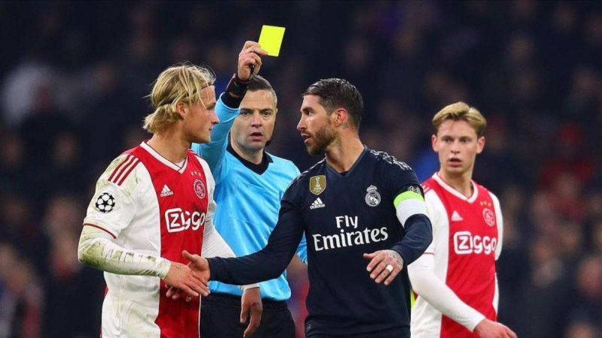 El árbitro le muestra la tarjeta amarilla a Sergio Ramos.