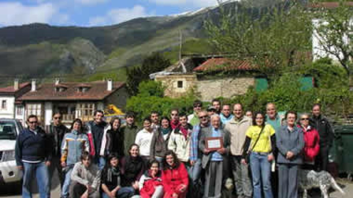 Alumnos y profesores del Aula Picos de Europa posan con Aurelio Fernández -con la placa-