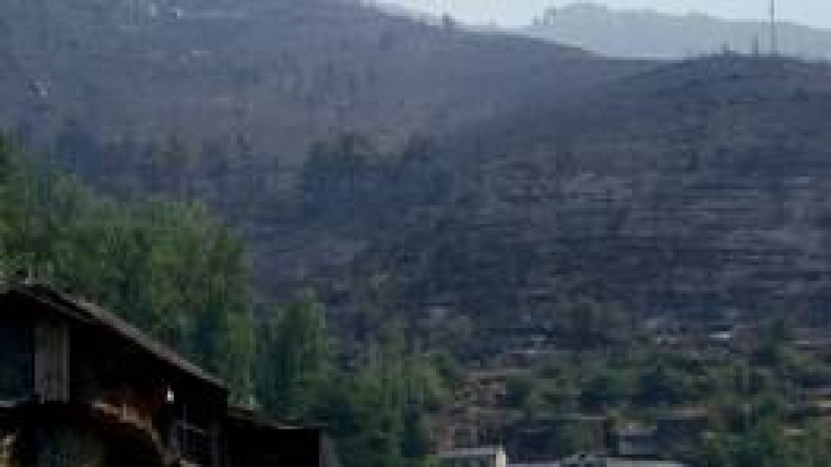 Imagen de Pombriego y al fondo los montes calcinados tras varios días de intenso y amenazante fuego