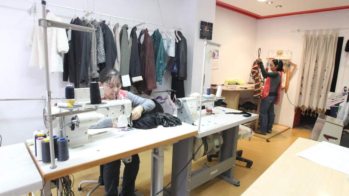 Las empleadas del Taller de Costura Patricia, realizando modificaciones en dos prendas.