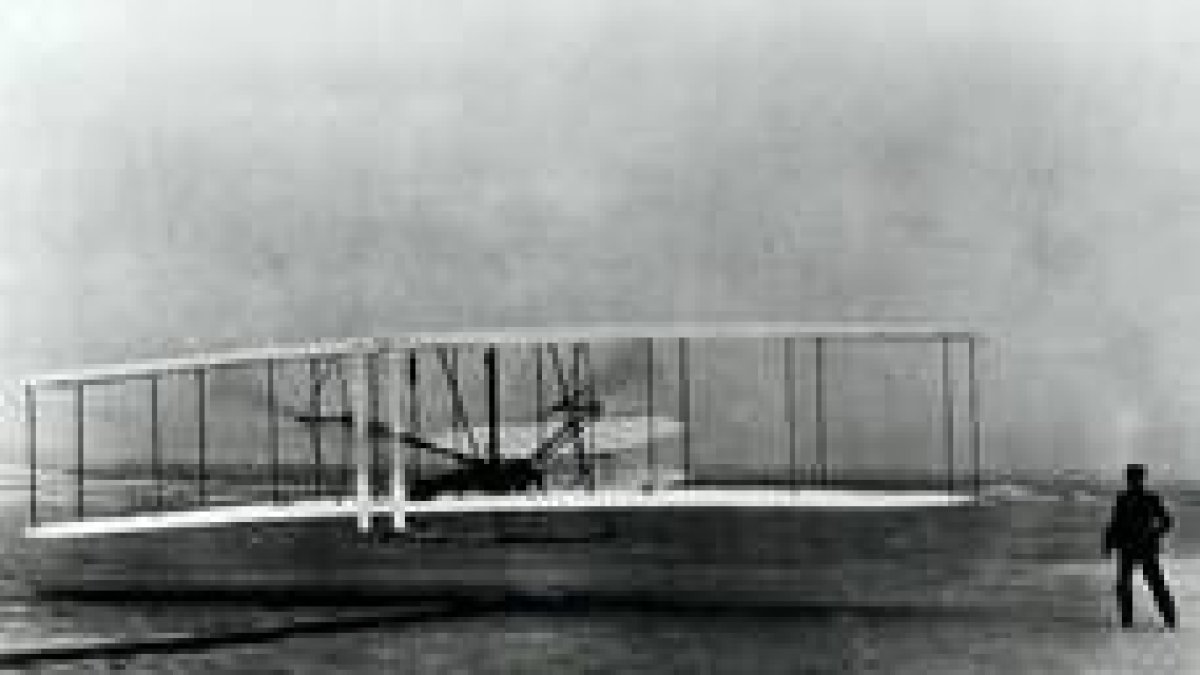 Wilbur Wright contempla como su hermano Orville inicia el vuelo que los inscribió en la historia