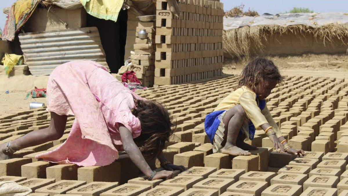 Dos niños ayudan a sus padres a sacar adelante la producción de ladrillos diaria. JULEN YUGUERO