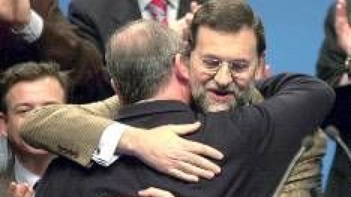 Rajoy y Rato se abrazan en el acto celebrado ayer