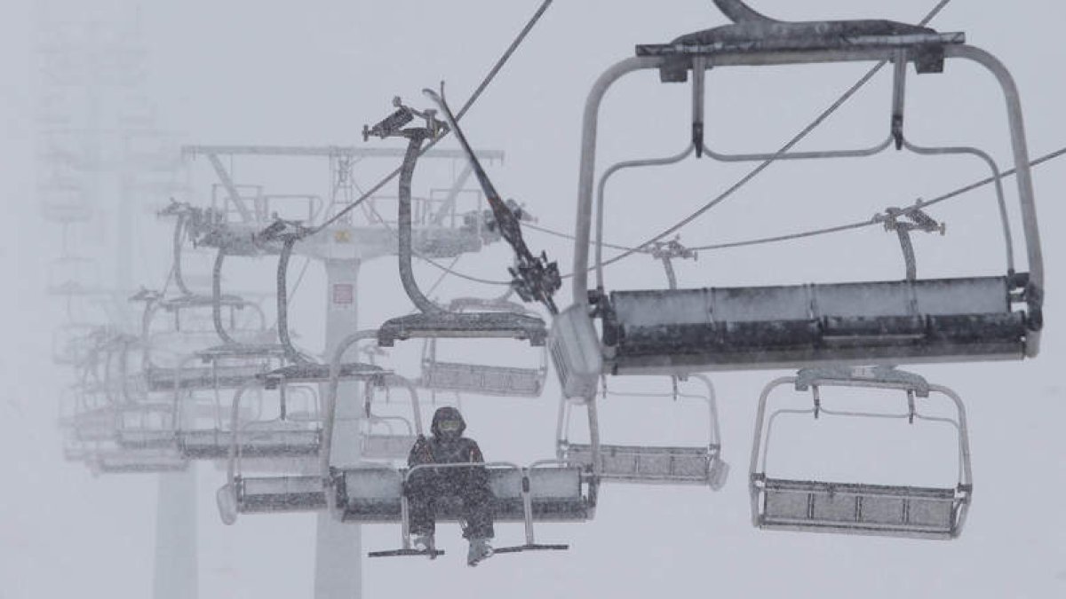 Un esquiador baja en solitario en el telesilla cuatriplaza de Cebolledo, ayer a mediodía en el momento en que arreciaba la ventisca