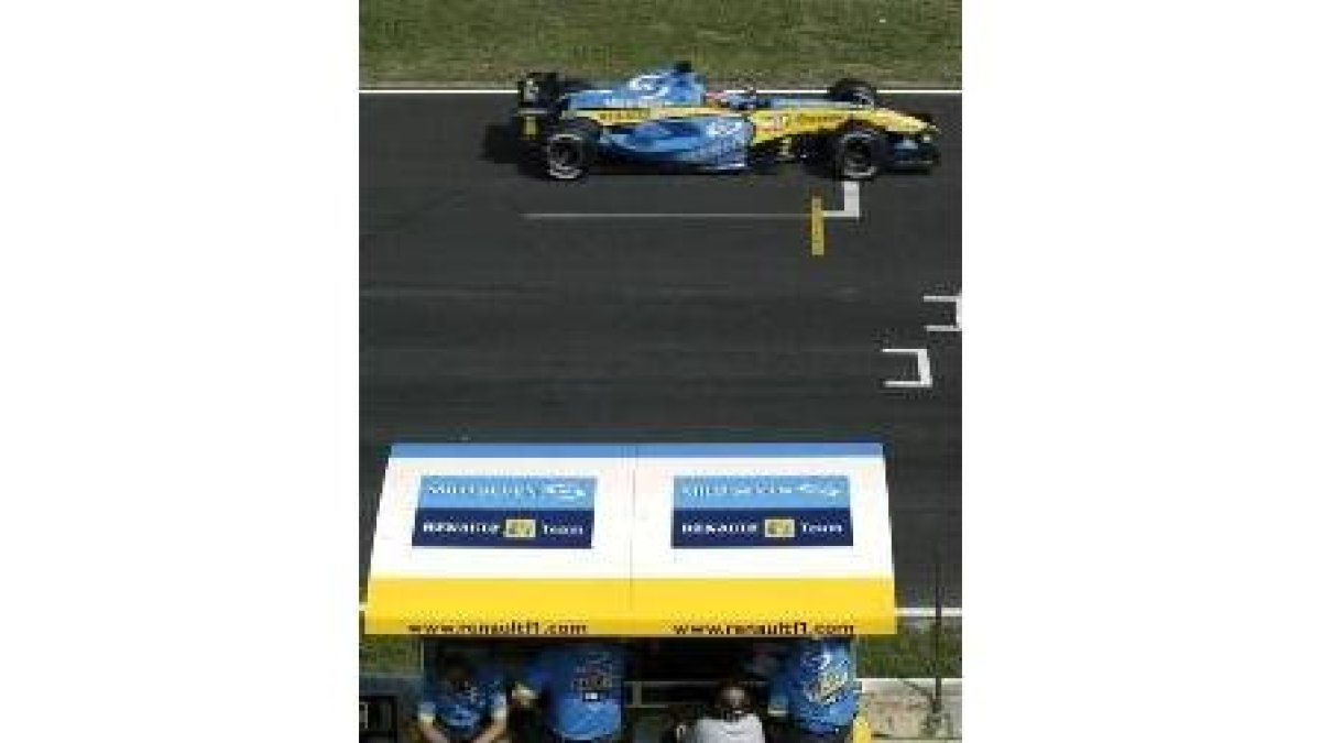 Alonso pasa con su coche en un entrenamiento frente a sus técnicos