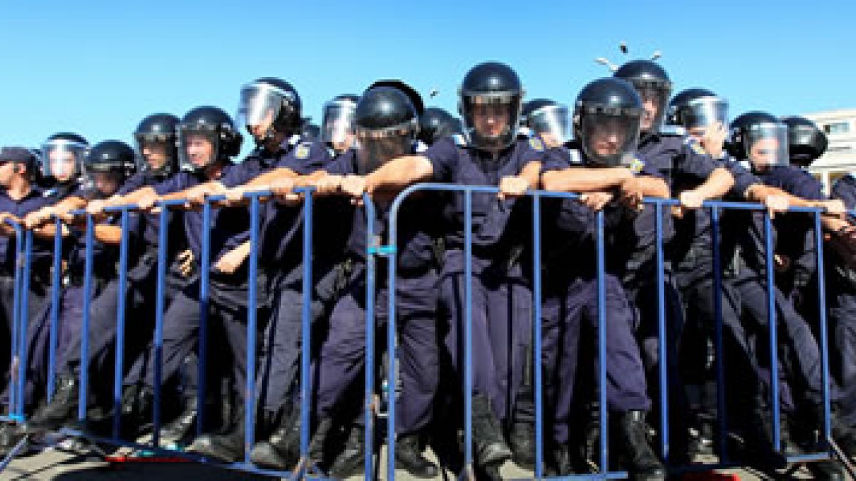 Agentes de policía aseguran una valla protectora durante una protesta de funcionarios rumanos