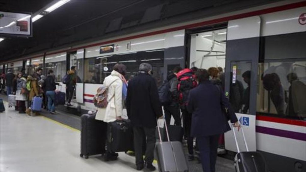 Unos pasajeros suben a un tren de Rodalies en la estación de Sants.