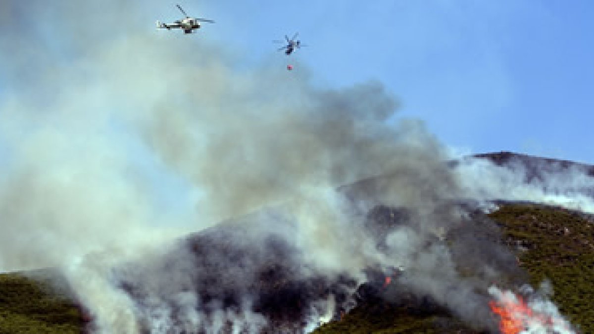 Dos helicópteros, uno de extinción y otro de vigilancia, sobrevuelan los montes de Oencia.
