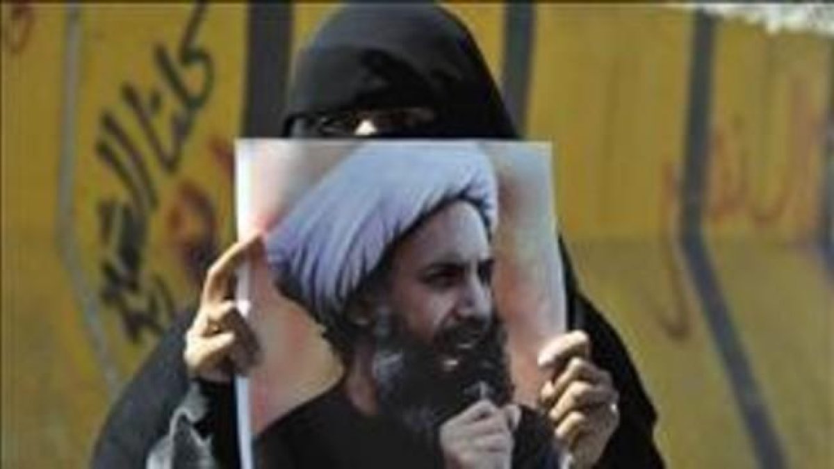 Una mujer sostiene en Yemen la foto del clérigo chií Al Nimr ajusticiado.