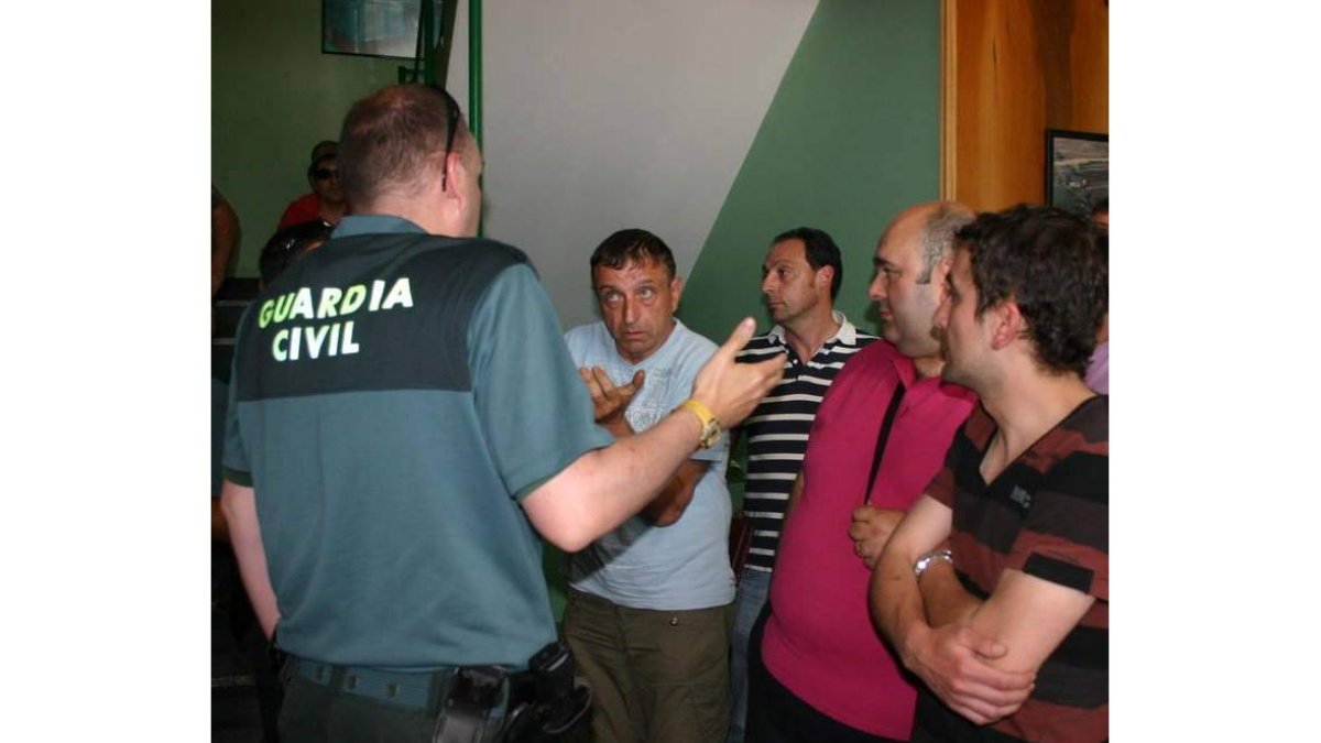Un grupo de trabajadores, dialogando con un guardia civil.