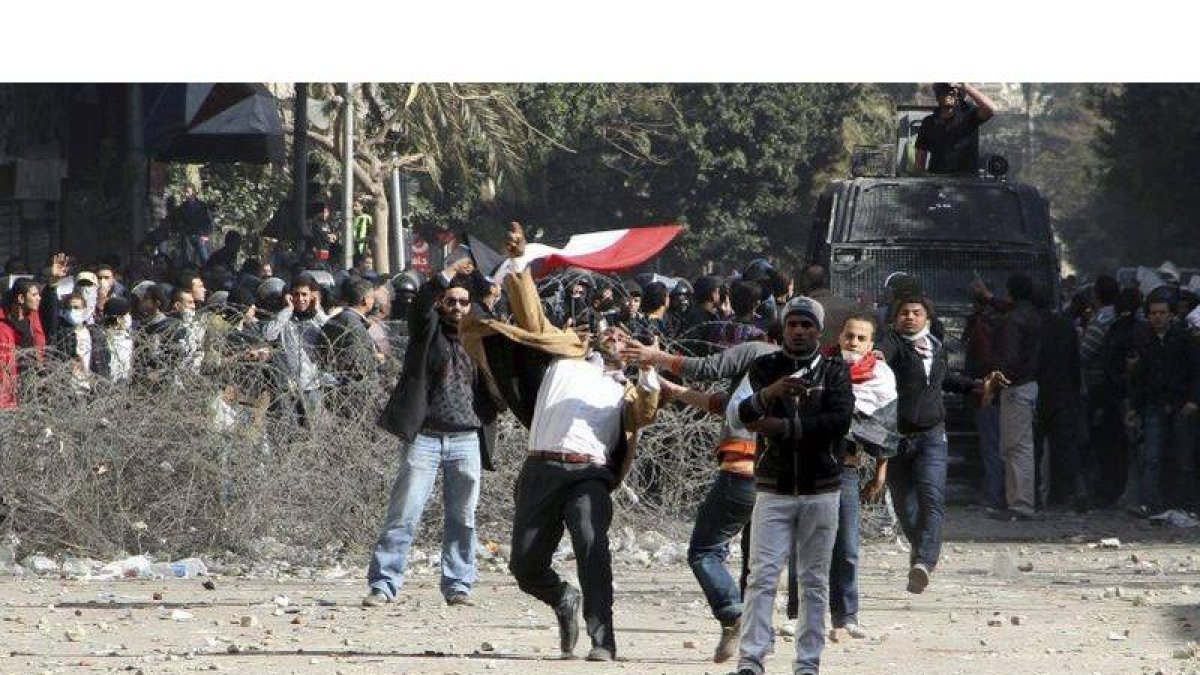 Varios manifestantes egipcios lanzan objetos a las fuerzas de seguridad cerca del Ministerio del Interior en El Cairo, Egipto, hoy, domingo 5 de febrero de 2012.