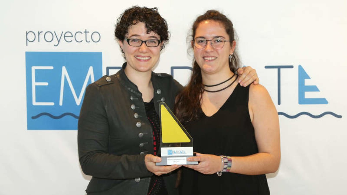 Estefanía Morcillo, psicóloga de la asociación, y Susana Cordero, educadora social, reciben el premio ayer en Barcelona. DL