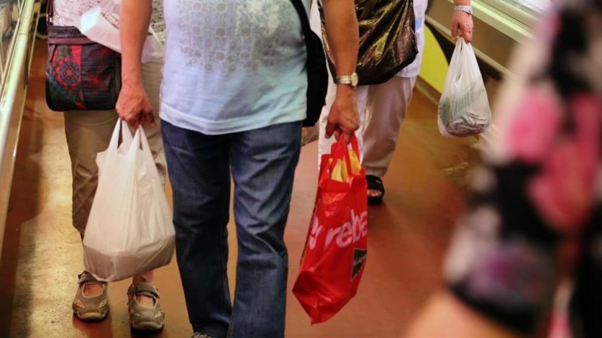 Un consumidor con bolsas de plástico.