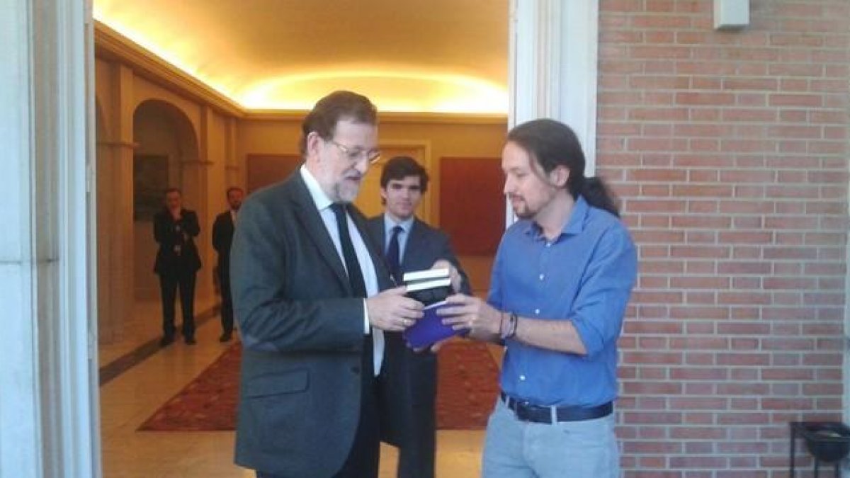 En el primer encuentro entre los dos líderes, el candidato a las presidenciales de Podemos le entrega un libro de Machado a Mariano Rajoy