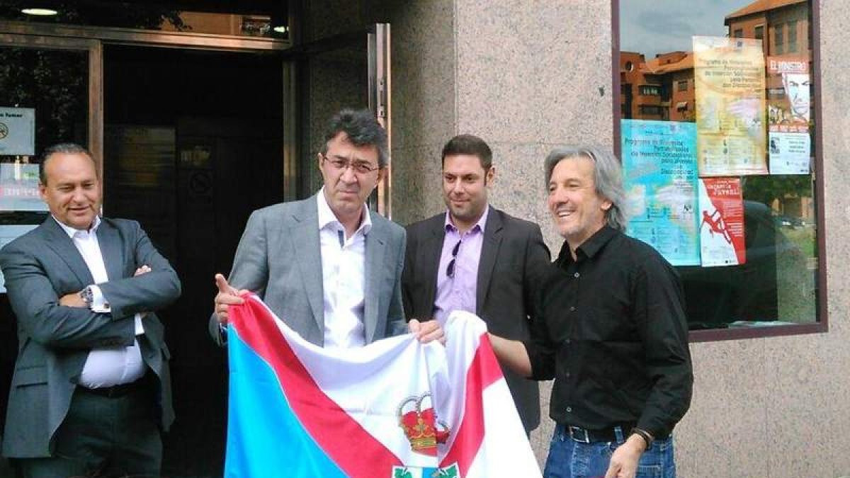 Majo sostiene la bandera del Bierzo que le entregaron Alonso y Muñoz en la sede de Diputación.