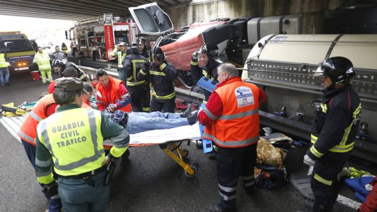 Efectivos de Bomberos, Guardia Civil y del Servicio de Emergencias de la Junta atienden al conductor herido.