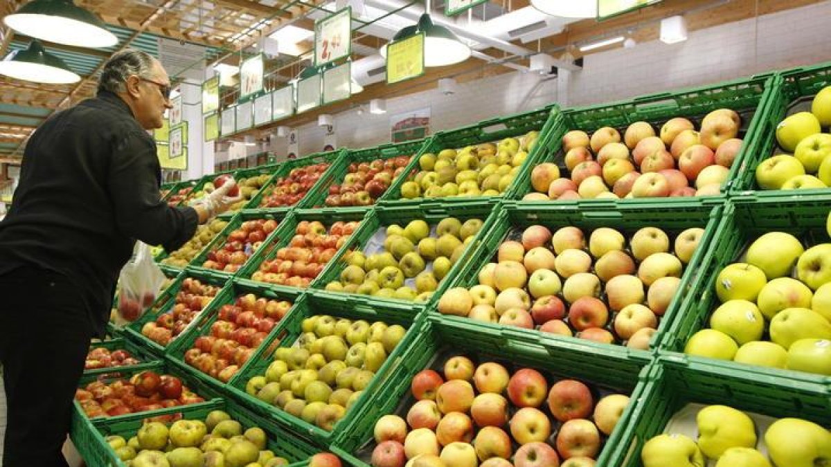 Un hombre escoge la fruta en un supermercado de León