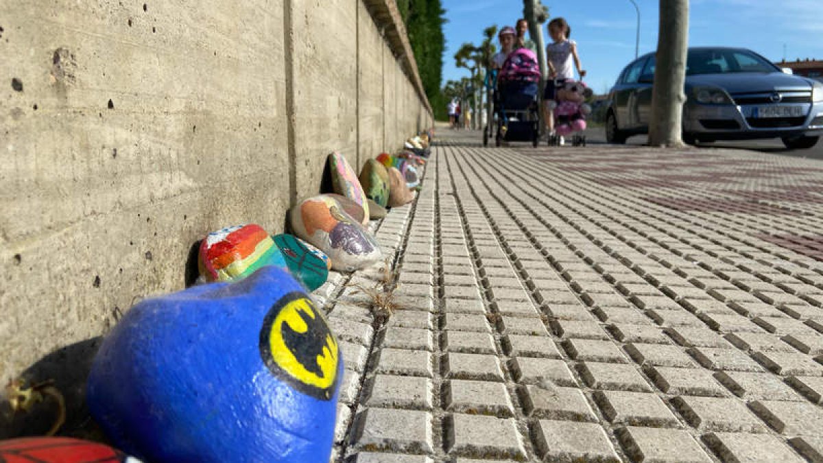 El sendero alegórico de piedras pintadas por los niños de Villaobispo ya ocupa un centenar de metros. RAMIRO