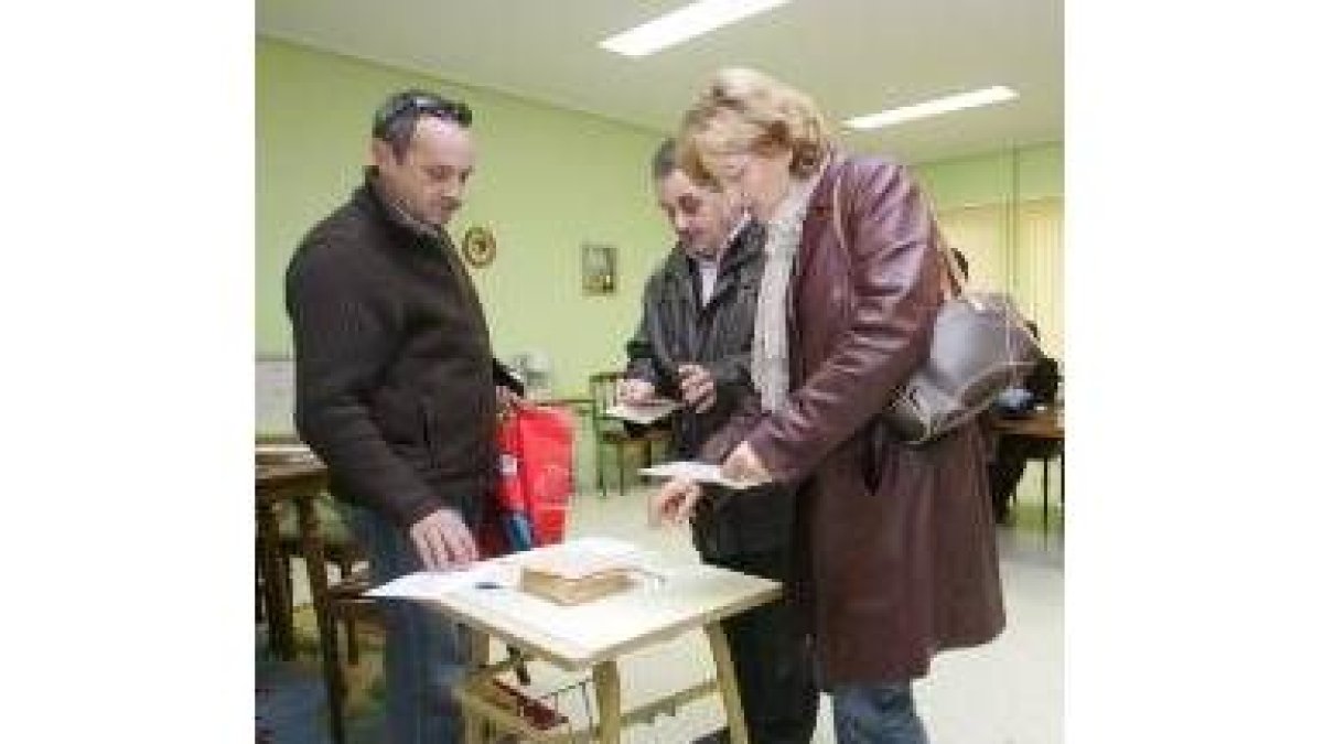 En la imagen, una madre se dispone a introducir su voto en una urna del San Claudio