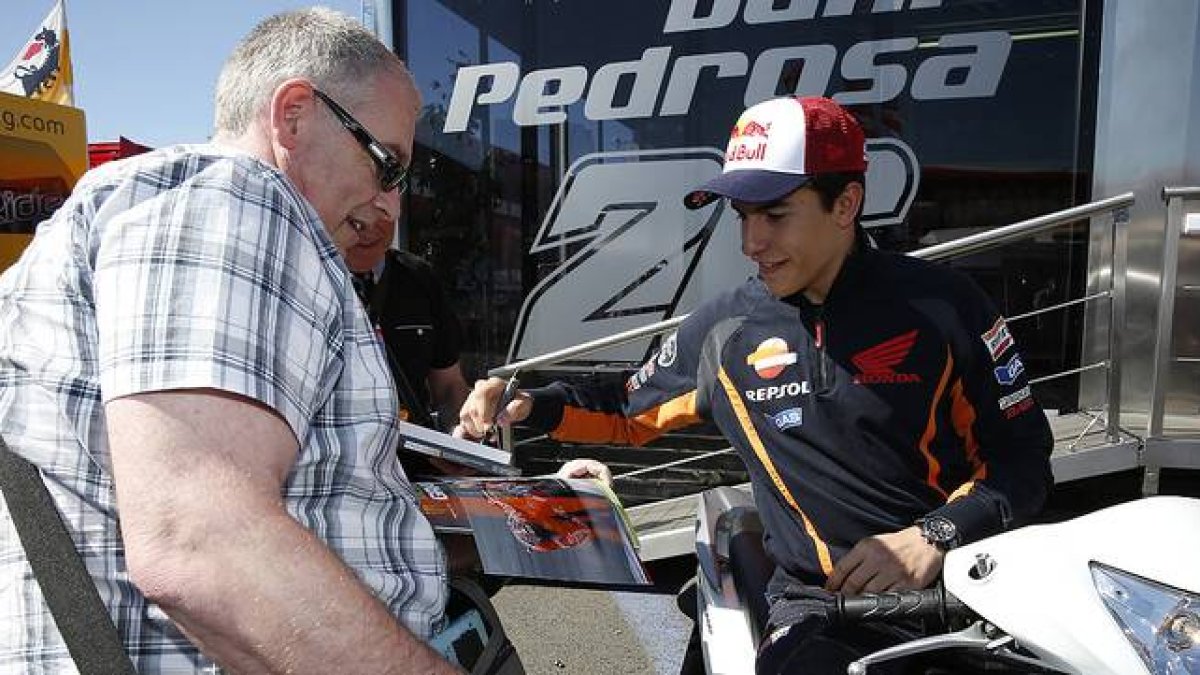 Marc Márquez firma un autógrafo a un aficionado en el circuito de Le Mans.