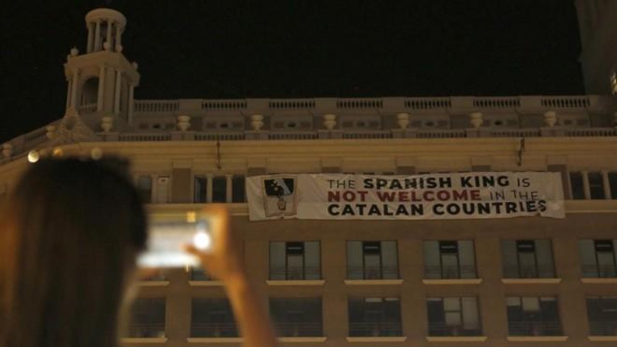 La pancarta que afirma que el Rey no es bienvenido a Catalunya, este jueves por la noche, 16 de agosto, en el edificio de plaça Catalunya, 9. La pancarta que afirma que el Rey no es bienvenido a Catalunya, este jueves por la noche, 16 de agosto, en el edi