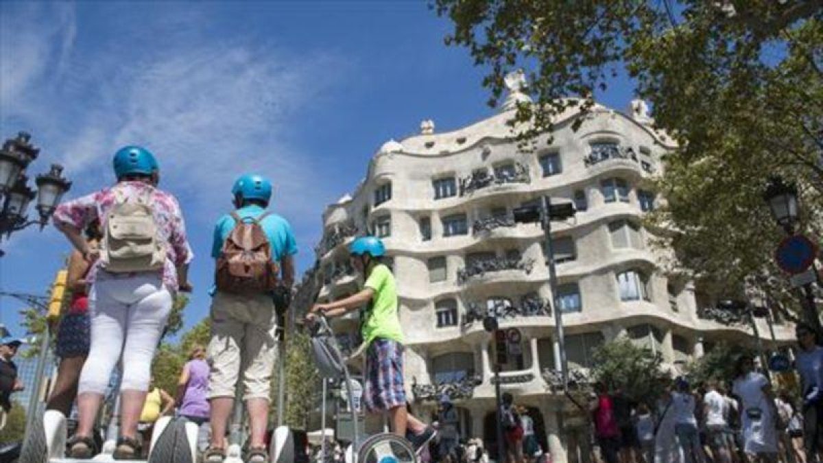 Turistas sobre 'segways' frente a La Pedrera, en Barcelona.