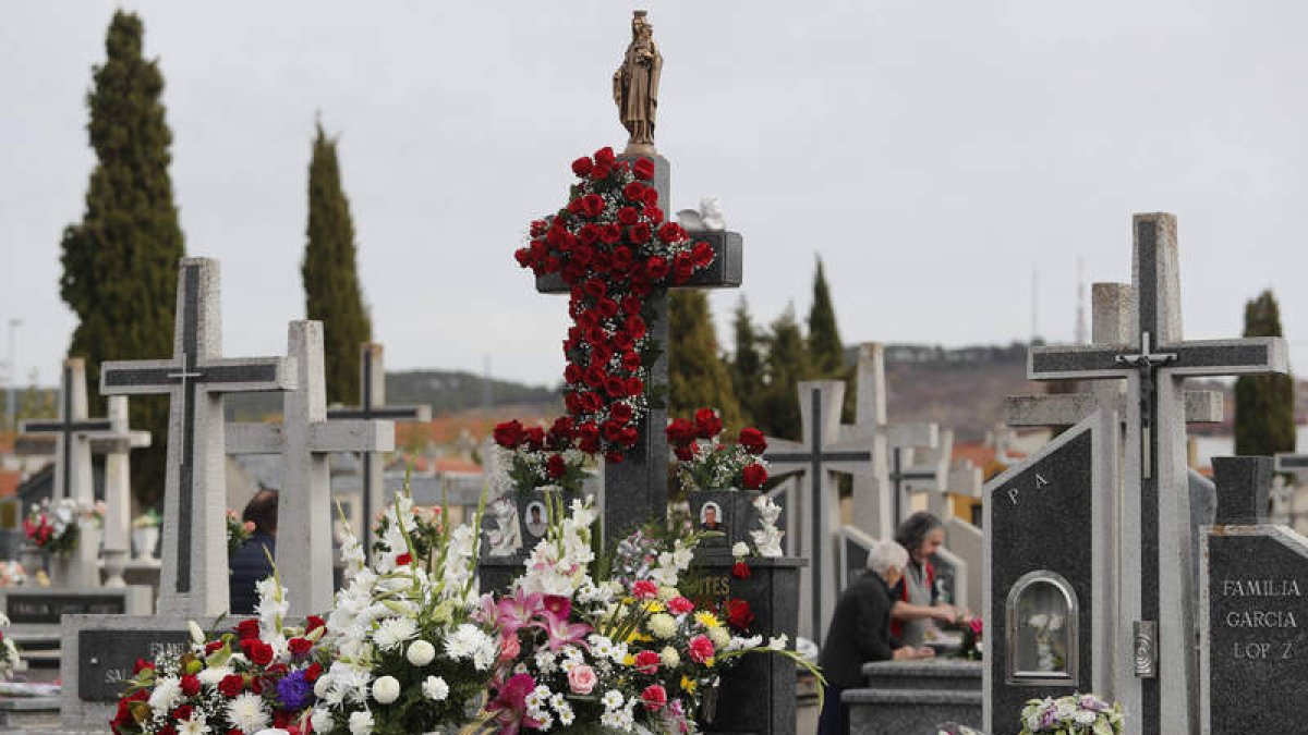 Las familias leonesas depositaron ayer en el cementerio sobre las tumbas de sus difuntos los ramos y coronas de flores, como manda la tradición. JESÚS F. SALVADORES