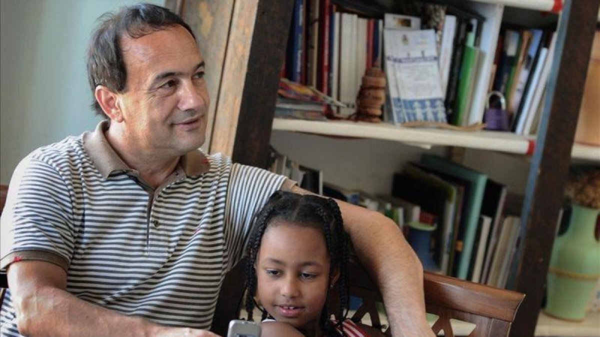 El alcalde de Lucano, Domenico Lucano, con una niña originaria de Etiopía.