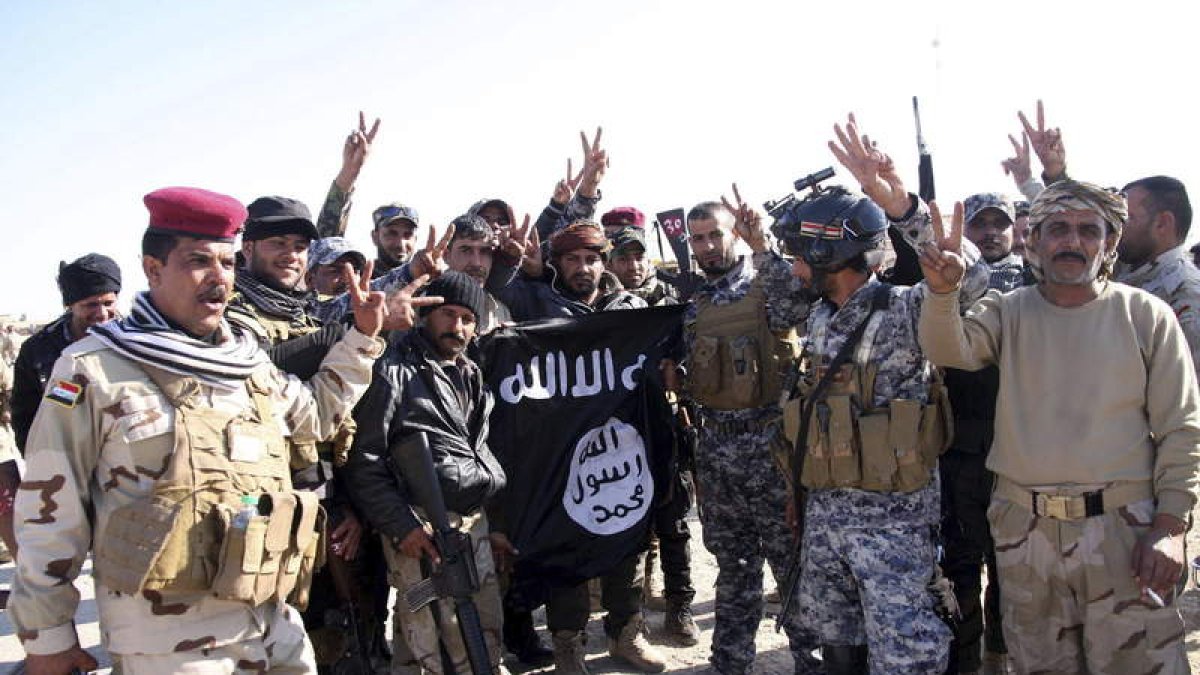 Soldados iraquíes posan con la bandera del Estados Islámico, en una imagen reciente.