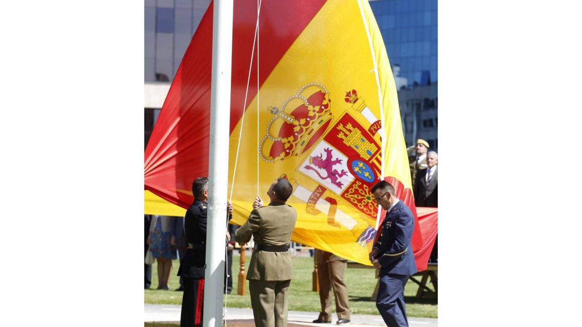 Izado de la nueva bandera de España, durante el acto de homenaje que ha tenido lugar este mediodía.